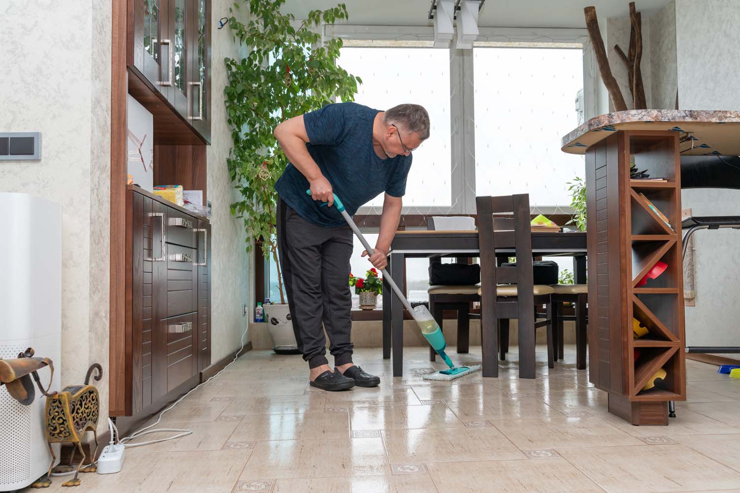 a-man-cleans-the-tiled-floor-in-an-apartment-with
