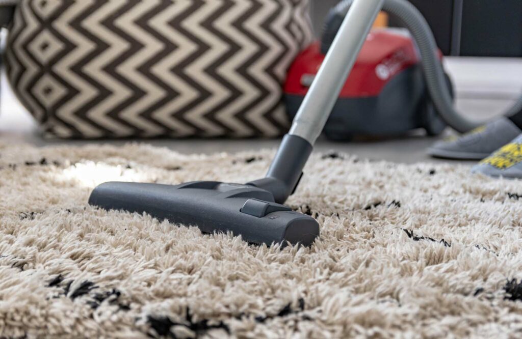 close-up-image-of-person-vacuuming-a-carpet-in-liv-2022-11-14-18-01-58-utc