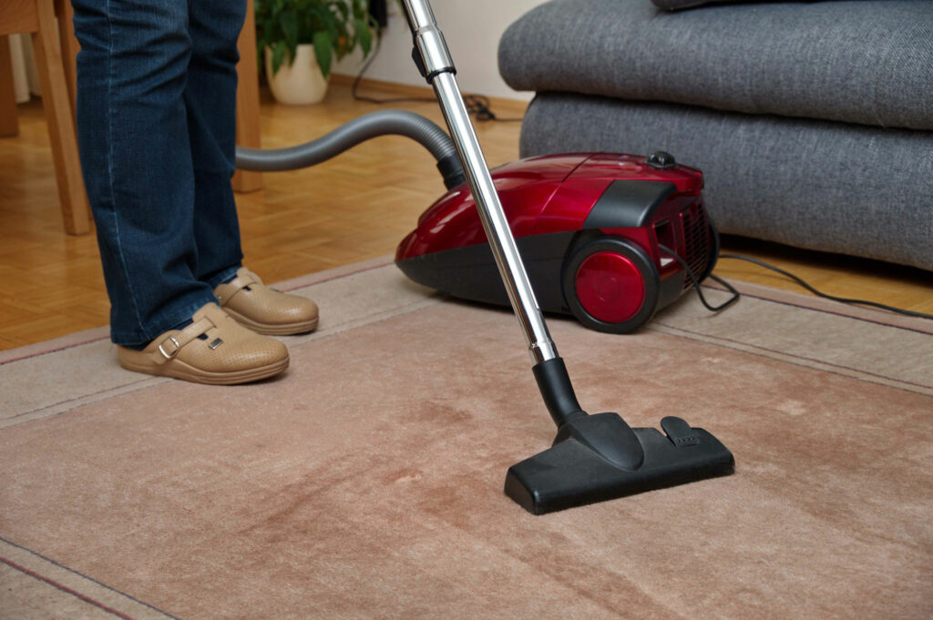 woman-using-a-vacuum-cleaner-while-cleaning-carpet-2022-11-17-00-00-05-utc